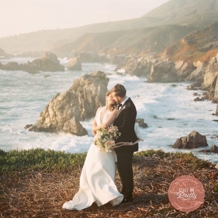 Bride and groom standing by the ocean